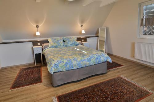 een slaapkamer met een bed en twee tapijten bij Gites La Maison Mann in Sand