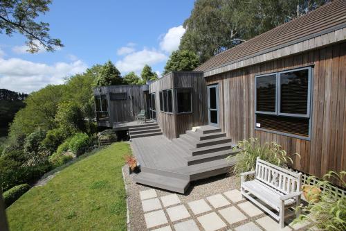 a wooden cabin with a porch and a bench at On The River in Hamilton