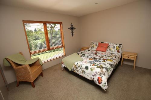 a bedroom with a bed and a chair and a window at On The River in Hamilton