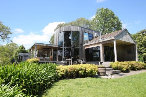 a house with a glass facade with a yard at On The River in Hamilton