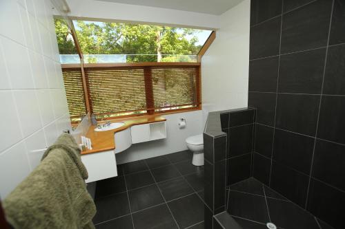 a bathroom with a window and a sink and a toilet at On The River in Hamilton