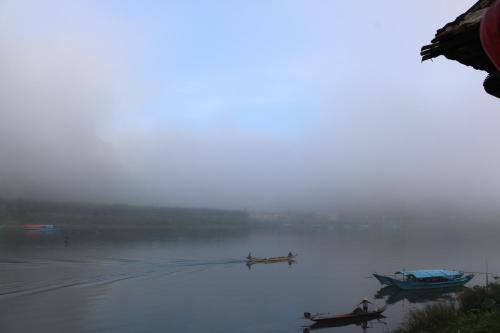 two boats on the water on a foggy lake at Phong Nha Coco House in Phong Nha