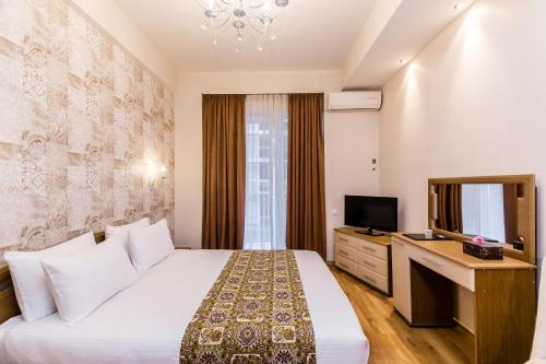 a hotel room with a bed and a television at Hotel Diamond in Tbilisi City