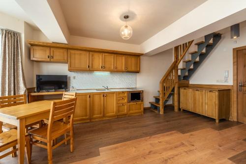 a kitchen with wooden cabinets and a wooden table at Pirin Golf & Country Club Apartment Complex in Bansko