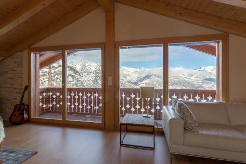 a living room with a view of snow covered mountains at Chalet Nid Blanc in Nendaz