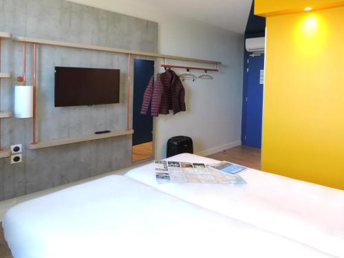 a bedroom with a bed and a tv on a wall at ibis budget Amiens Centre Gare in Amiens