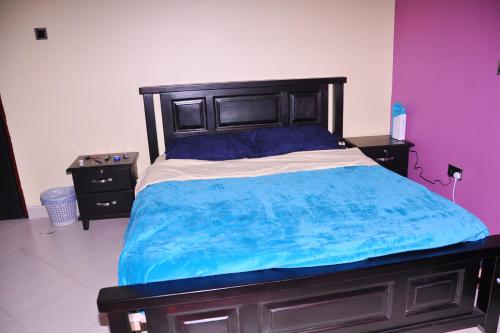 a bedroom with a large bed with blue sheets at Seguku Katale Apartment 1 in Katale