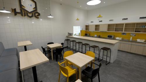 um restaurante com mesas e cadeiras e um balcão em The Hive Party Hostel Budapest em Budapeste