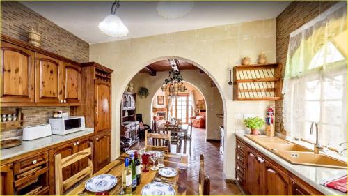 a large kitchen with an archway in a room at Great Seaviews Location - FREE Gozo taxi service, Fast WIFI, Bicycles, BBQ & Parking, No Car needed in Għajnsielem