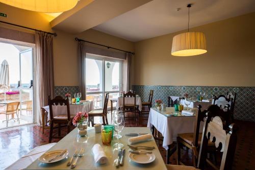 a dining room with tables and chairs in a restaurant at Pousada de Sagres in Sagres