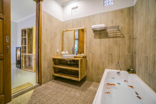 y baño con bañera y lavamanos. en Ubud Tropical Garden 2 en Ubud