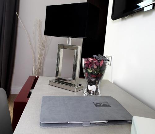 a table with a vase of roses and a lamp at Partenope Relais in Naples