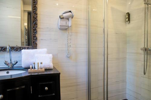 a bathroom with a shower and a sink at Hôtel Les Voyageurs in Bastia