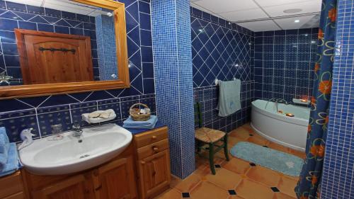 a blue tiled bathroom with a sink and a tub at Mediterranea Seaviews Gozo in Għajnsielem