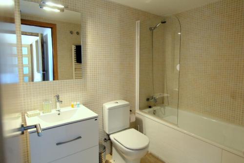 y baño con aseo, lavabo y ducha. en LEON INMO Apartment Oasis - 10022, en Empuriabrava