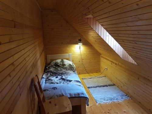 Cette chambre comprend un lit dans une cabane en bois. dans l'établissement Pähni külalistemaja, à Rõuge