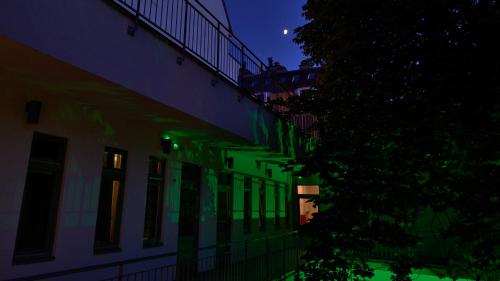 a building with green lights on the side of it at night at The Hive Party Hostel Budapest in Budapest
