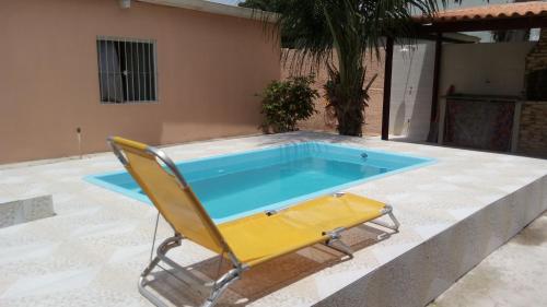 una silla y una piscina con una silla y una piscina en Casa temporada próximo a Praia do Forte Cabo Frio c piscina até 10 pessoas incluindo crianças, ligue e confira nossa oferta, en Cabo Frío