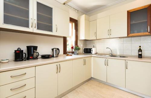 a kitchen with white cabinets and a sink at Afitos Hidden Gems #FeelsLikeHome in Afitos
