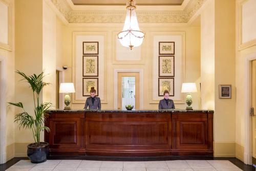 two people sitting at a reception desk in a lobby at The Imperial Torquay in Torquay
