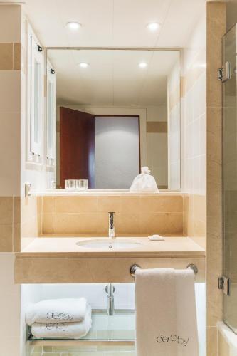łazienka z umywalką i lustrem w obiekcie Hotel Derby w Barcelonie
