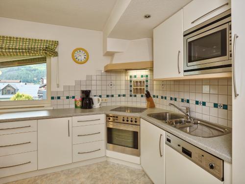 a kitchen with white cabinets and a sink and a window at Apparthof Sunnwies in Oetz