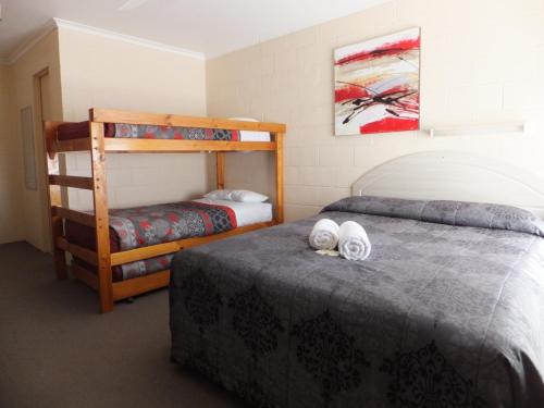 a bedroom with two beds and a bunk bed at Nagambie Caravan Park & Motel in Nagambie