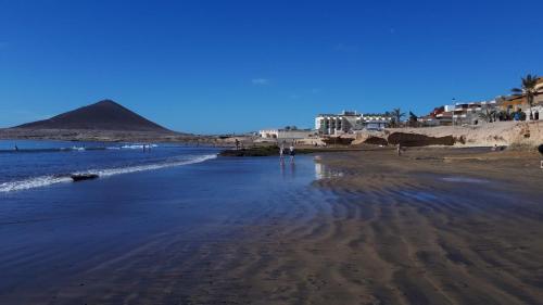 a view of a beach with a pyramid in the background at Las Princesas in El Médano