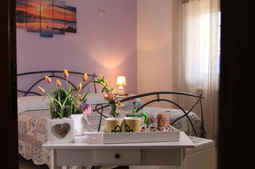 un lit avec une table avec des fleurs dessus dans l'établissement Dimora Pompeiana, à Pompéi