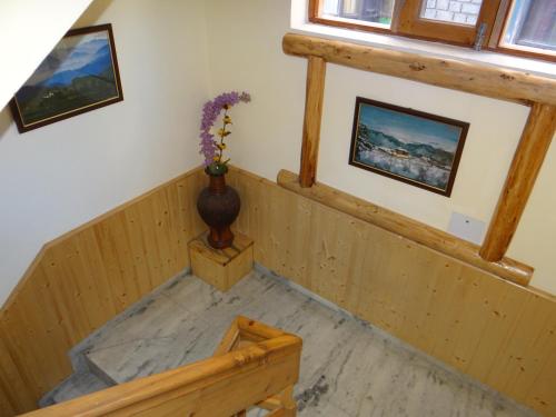 a room with a staircase with a vase of flowers at Hotel Mountain Trail Manali in Manāli