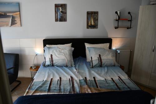 a bed with two pillows on it in a room at B&B Waddenzeetexel in Oudeschild