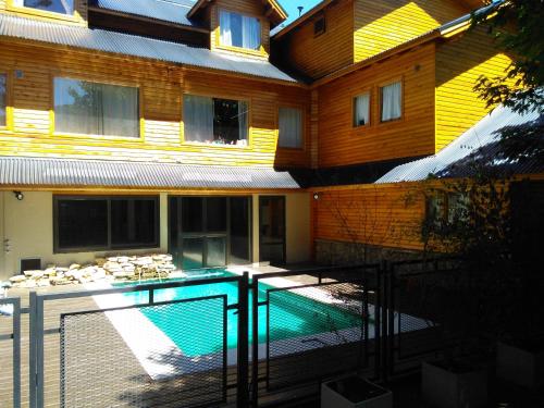 une maison avec piscine devant un immeuble dans l'établissement Las Golondrinas, à San Martín de los Andes