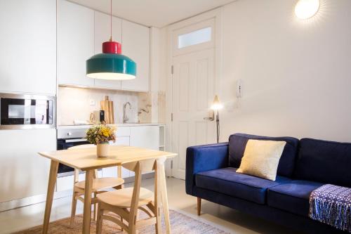 a living room with a blue couch and a table at Oporto Sweet Home I in Porto