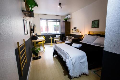 Meu lugar na Cidade Baixa في بورتو أليغري: غرفة نوم مع سرير وغرفة معيشة