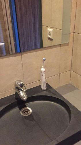 a bathroom sink with a soap dispenser on top of it at Dunez men only resort in Drunen