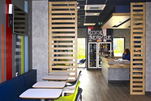 a restaurant with tables and chairs and a counter at ibis budget Amiens Centre Gare in Amiens