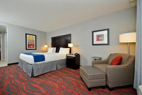 a hotel room with a bed and a chair at Holiday Inn Express Canandaigua by IHG in Canandaigua