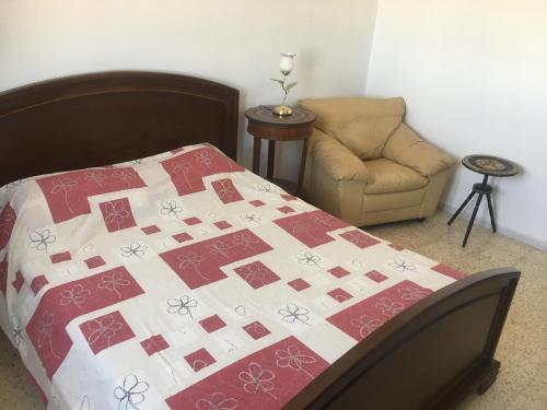 a bedroom with a bed and a chair at Sidi Mansour Route Touristique in Sfax