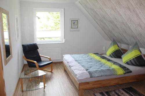 een slaapkamer met een bed, een stoel en een raam bij Ferienwohnung in der Natur in Drolshagen