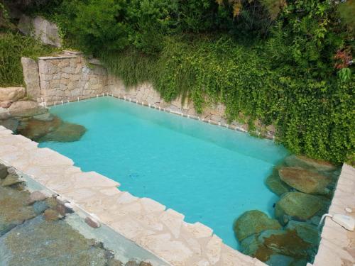 - une vue sur la piscine d'eau bleue dans l'établissement Villas Valinco Capicciolo vue-proche mer-piscines, à Olmeto