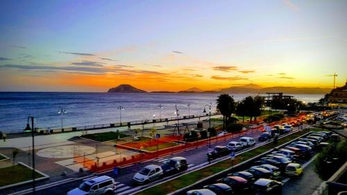 a parking lot with cars parked next to the ocean at B&B del Mare in Pozzuoli