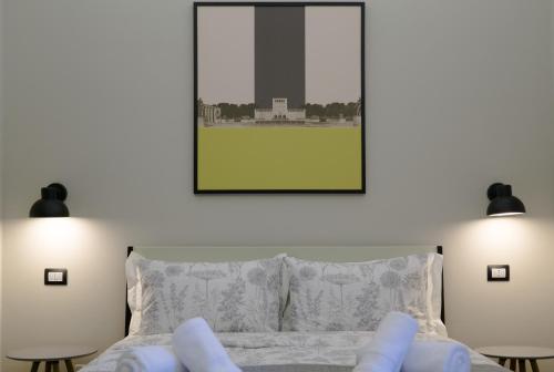 a bedroom with a bed with two lamps and a picture at Destil B&B in Tirana