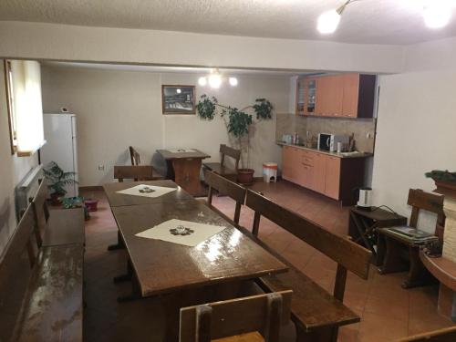 a dining room with tables and chairs and a kitchen at Guest Rooms Vachin in Bansko