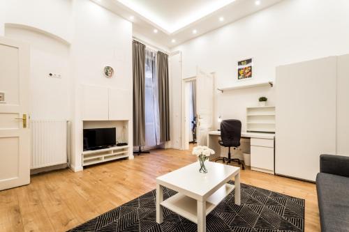 Hello Downtown Apartment - Boulevard في بودابست: غرفة معيشة مع أريكة وطاولة