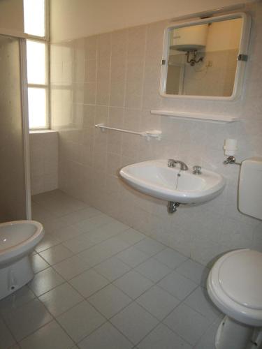 a white bathroom with a sink and a toilet at Occidente in Lignano Sabbiadoro