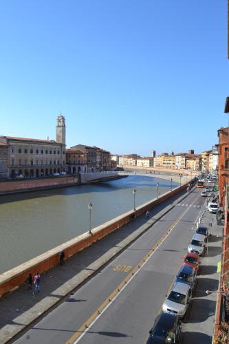 a bridge over a river with cars parked on the street at You & Me in Pisa
