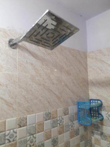 y baño con ducha con cabezal de ducha. en Buddha Guest House, en Varanasi