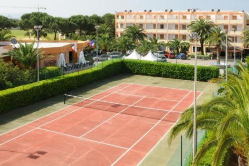 a tennis court in front of a building at Hotel Oasis in Alghero