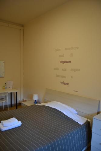 a bedroom with a bed with a sign on the wall at You & Me in Pisa