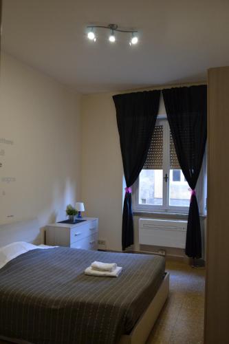 a bedroom with a bed with black curtains and a window at You & Me in Pisa